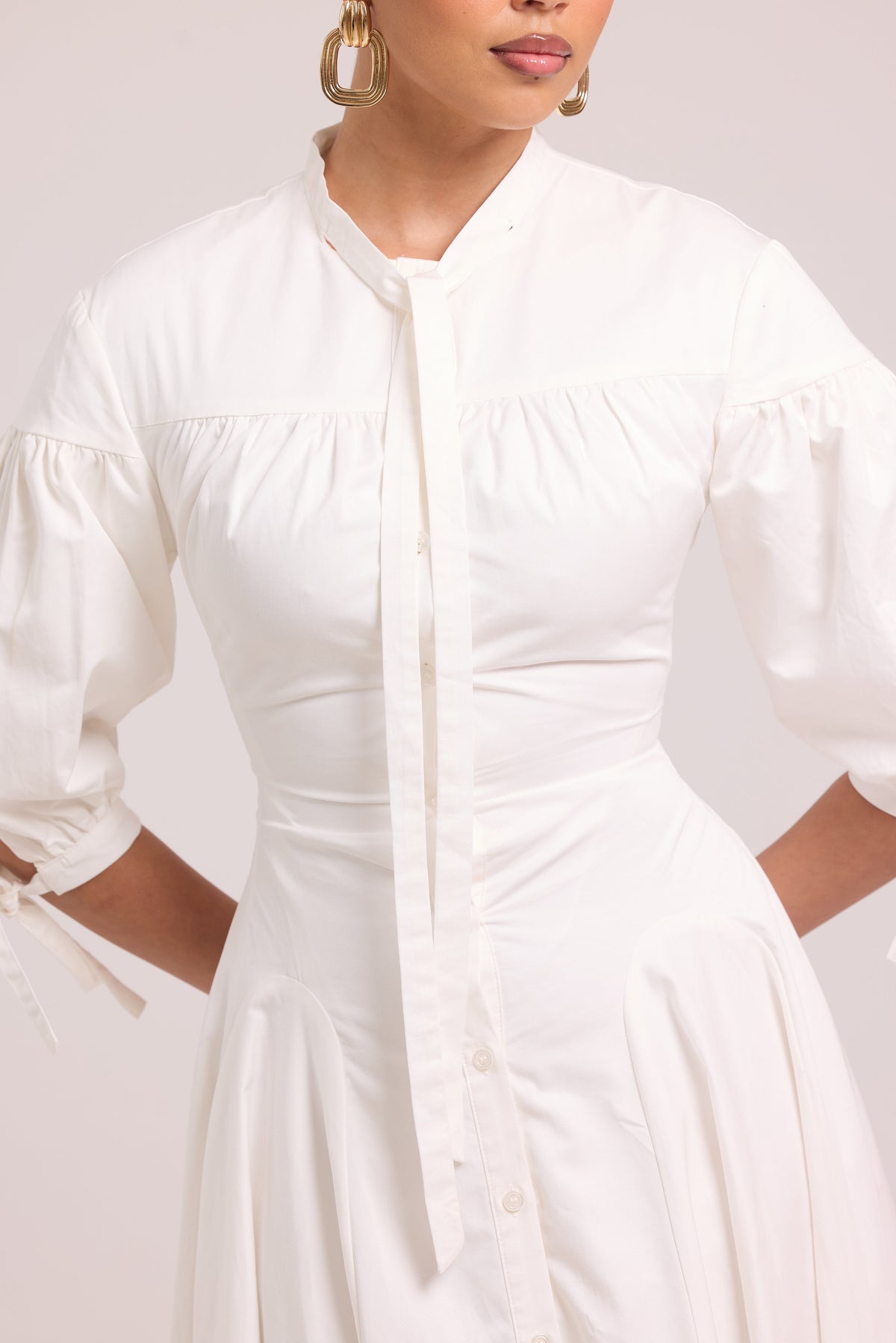 White shirt dress with shaped seams, full skirt, and lace-up back